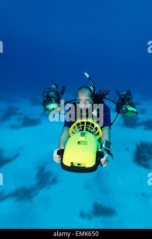 Divers with diver propulsion vehicles exploring a coral reef, Soma Bay, Hurghada, Egypt, Red Sea Stock Photo