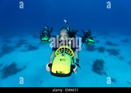 Divers with diver propulsion vehicles exploring a coral reef, Soma Bay, Hurghada, Egypt, Red Sea Stock Photo