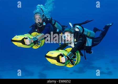 Divers with diver propulsion vehicles exploring a coral reef, Soma Bay, Hurghada, Egypt, Red Sea Stock Photo