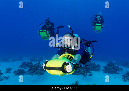 Divers with diver propulsion vehicles exploring a coral reef, Soma Bay, Hurghada, Egypt, Red Sea Stock Photo