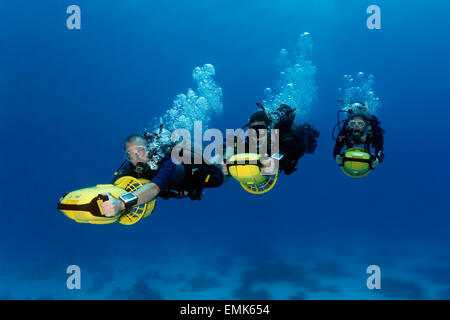 Divers with diver propulsion vehicles exploring a coral reef, Soma Bay, Hurghada, Egypt, Red Sea Stock Photo