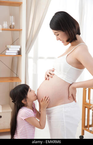 The little girl kissed her mother's belly Stock Photo