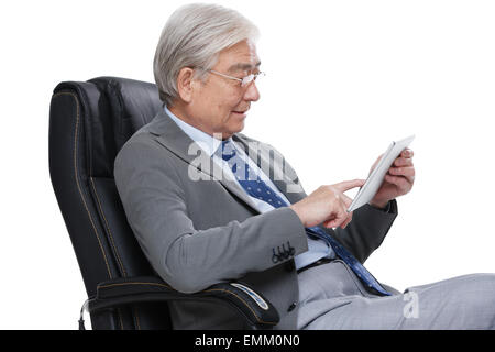 An old man sat in the chair using the tablet computer