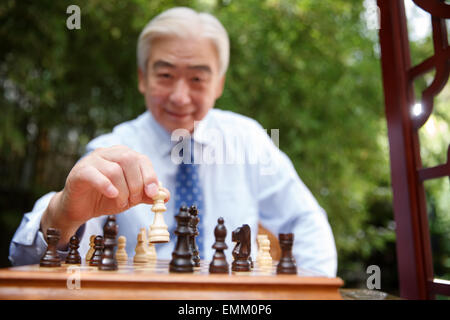 An old man in chess in the yard Stock Photo