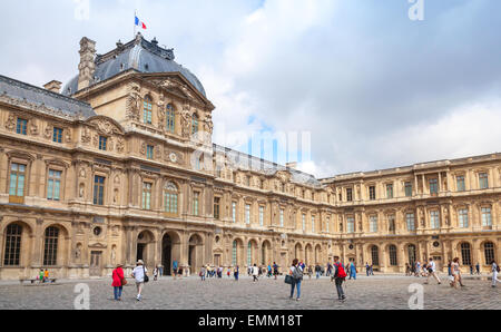 Paris, France - August 09, 2014: Inner courtyard and exterior of The Louvre Museum with walking tourists in a summer day Stock Photo