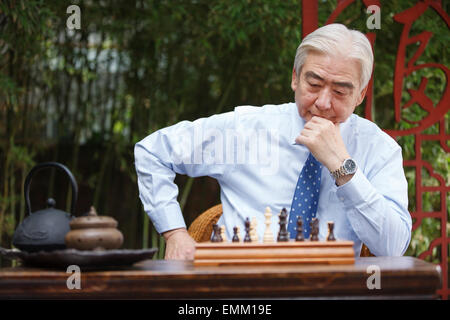 An elderly man looked at chess in thinking Stock Photo