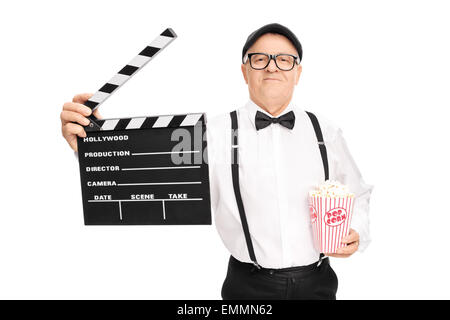 Mature movie director holding a clapperboard and a box of popcorn isolated on white background Stock Photo