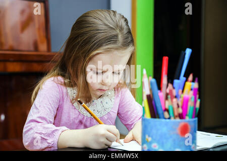 Cute little girl studing to speaking and writing letters at home lesson with her mother Stock Photo