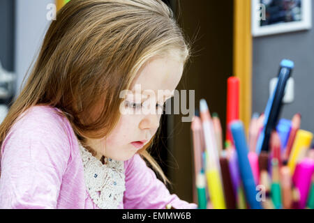 Cute little girl studing to speaking and writing letters at home lesson with her mother Stock Photo