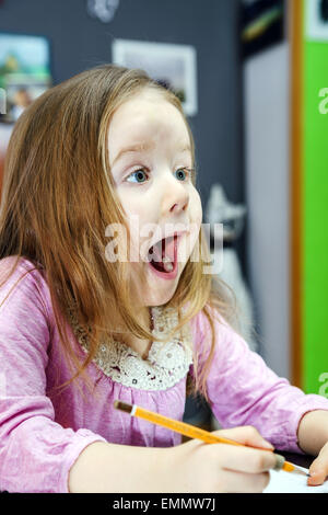 Cute little girl studing to speaking and writing letters at home lesson with her mother Stock Photo