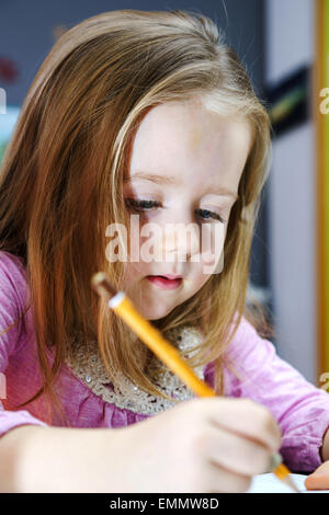 Cute little girl studing to speaking and writing letters at home lesson with her mother Stock Photo