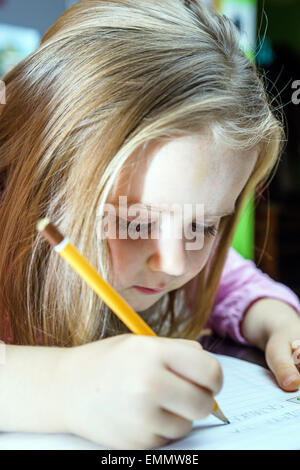 Cute little girl studing to speaking and writing letters at home lesson with her mother Stock Photo