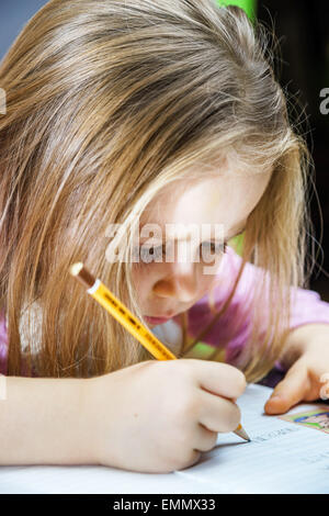 Cute little girl studing to speaking and writing letters at home lesson with her mother Stock Photo