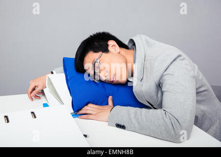 Young handsome asian businessman in glasses sleepig on the table Stock Photo