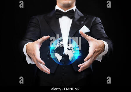 magician in top hat showing globe hologram Stock Photo