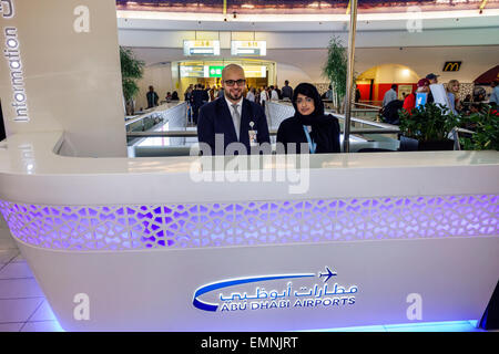 Abu Dhabi United Arab Emirates UAE,International Airport,AUH,terminal,gate,interior inside,information,desk,help,Arabic English,man men male,woman fem Stock Photo