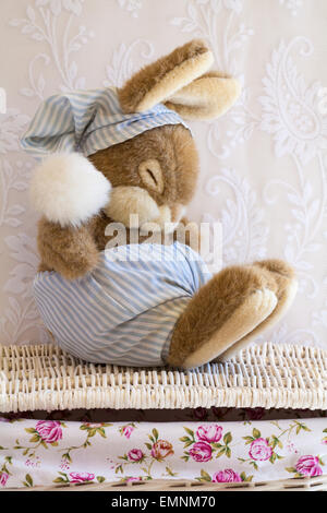 Sleeping Easter bunny rabbit soft cuddly toy sitting on wicker basket Stock Photo