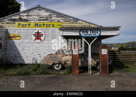 Old abandoned petrol station with a Plymouth Belvedere 1950s car, and two petrol pumps,  rotting on the forecourt. Ormondville, Stock Photo