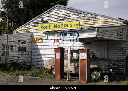 Old abandoned petrol station with a Plymouth Belvedere 1950s car, and two petrol pumps,  rotting on the forecourt. Ormondville, Stock Photo