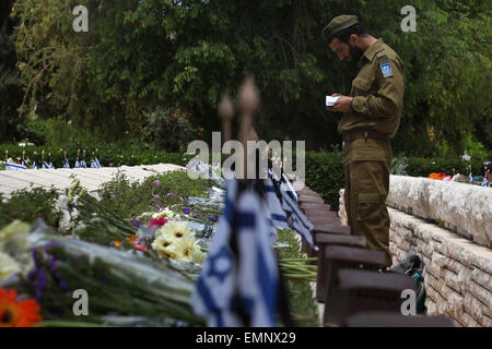 Jerusalem, Israel. 22nd Apr, 2015. An Israeli soldier pays tribute to his fallen comrade at a cemetery during a Remembrance Day commemoration in Tel Aviv, Israel, on April 22, 2015. Israel on Wednesday marks Remembrance Day to commemorate its fallen soldiers. © Gil Cohen Magen/Xinhua/Alamy Live News Stock Photo