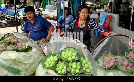 Bangkok, Thailand:  Thai couple selling bunches of Lotus buds at the Thanon Chakaphet outdoor flower market Stock Photo