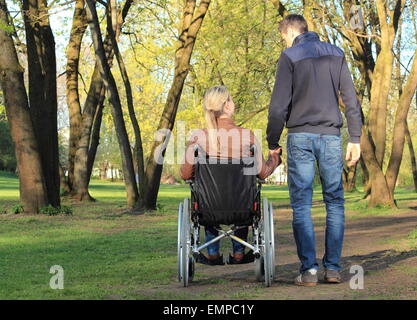 A Lovers couple in wheelchair and not handicapped Stock Photo