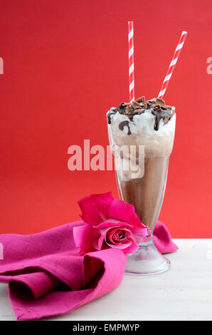 Iced coffee drink in classic soda pop glasses in modern cafe style red and pink background on white vintage wood table. Stock Photo