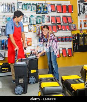 Woman Selecting Tool Cases In Hardware Store Stock Photo