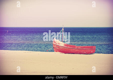 Vintage filtered photo of an old abandoned boat on the beach. Stock Photo