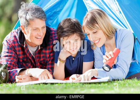 Family Looking At Map In Tent Stock Photo