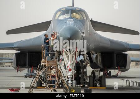 A US Air Force crew chiefs prepare a B-1B Lancer stealth bomber for a mission against Islamic State fighters at Al Udeid Airbase April 8, 2015 in Qatar. Stock Photo