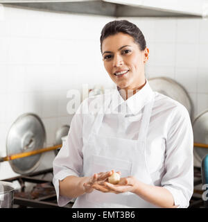 Smiling Chef Holding Pasta Dough Ball In Kitchen Stock Photo