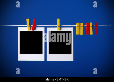 instant photos hanging on the wire with the colored pegs Stock Photo