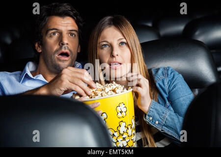 https://l450v.alamy.com/450v/emt5km/shocked-couple-watching-movie-in-theater-emt5km.jpg