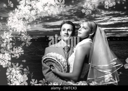Monochrome picture of bride and groom standing together near the river Stock Photo