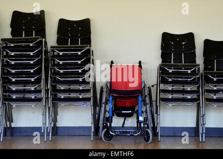 A wheelchair standing between other chairs./picture alliance Stock Photo