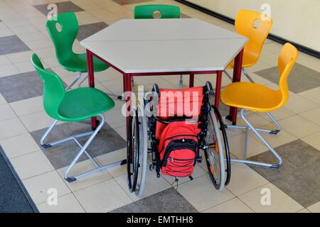 A wheelchair standing between other chairs./picture alliance Stock Photo