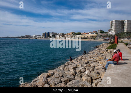 Men fishing on a summers day from the promenade in Spain Stock Photo