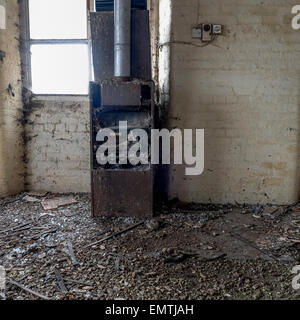 Old boiler in a disused factory with lots of debris on the floor. Stock Photo