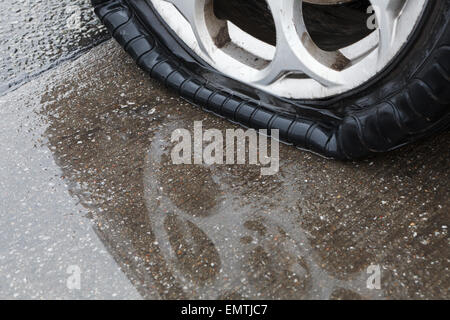 Flat tire on wet road Stock Photo