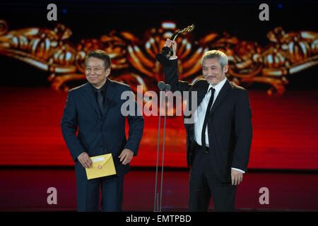 (150423) -- BEIJING, April 23, 2015 (Xinhua) -- Director of the movie 'The Taking of Tiger Mountain' Hark Tsui (R) receives the Tiantan Award for Best Supporting Actor on behalf of Tony Leung Ka Fai during the awarding ceremony of the Tiantan Award of the fifth Beijing International Film Festival (BJIFF) in Beijing, capital of China, April 23, 2015. (Xinhua/Chen Jianli) (mp) Stock Photo