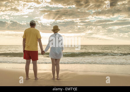 Senior man and woman holding hands of each other at the beach Stock Photo