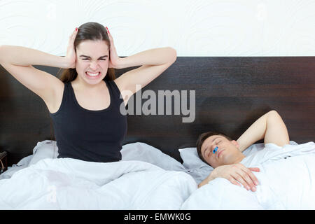 Young girl being angry on snoring boyfriend. Unhappy woman and her snoring husband. I still hear you loud. Person disturbed by s Stock Photo