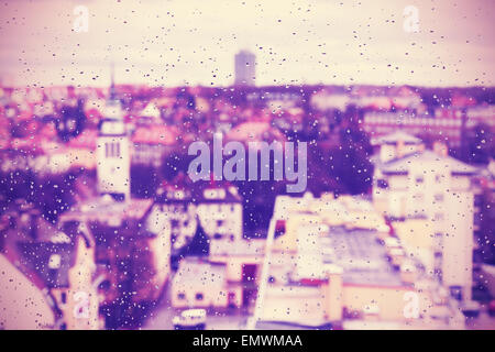 Purple abstract blurred urban background made of rain drops on window. Stock Photo