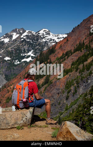 WASHINGTON - Hiker taking in view of Red and Snoqualmie Mountains from Pacific Crest Trail at southern end of Kendall Katwalk. Stock Photo