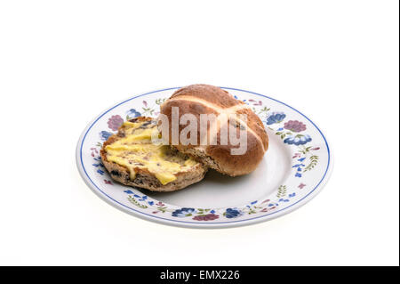 Hot cross bun on a round, decorated plate. Stock Photo