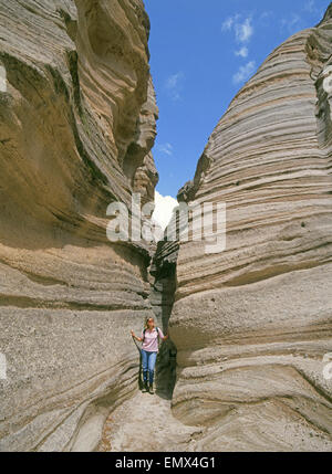 A hiker explores a slot canyon in Kasha-Katuwe Tent Rocks National Monument, near the Cochiti Indian Reservation in central New Mexico along the Rio Grande. The cliffs here are made from pumice and tuff, a result of volcanic action eons ago. Stock Photo
