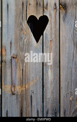 wooden restroom door with cut heart shape Stock Photo