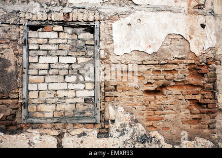 Old grungy wall with boarded up window Stock Photo