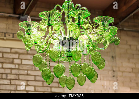 Chandelier hanging against a brick wall in a converted warehouse building. Stock Photo